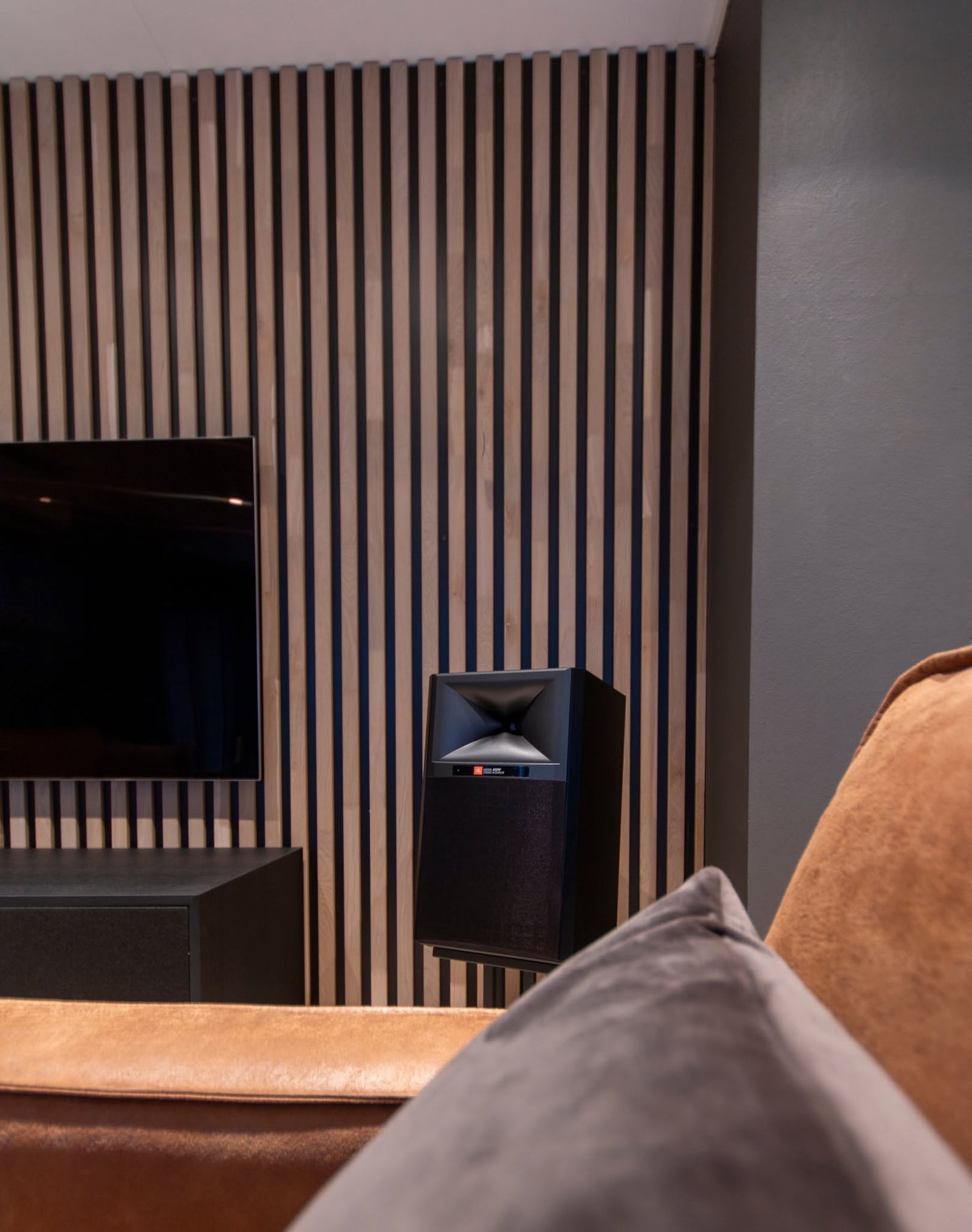 Demorommet til Bach’s HiFi i Tomrefjord med JBL-høyttaler, TV og spilevegg