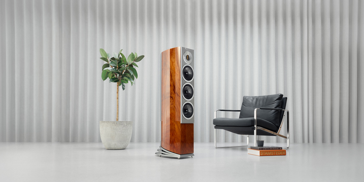 Audiovector R 5 Arreté i trefinish med grå front, vist fra siden og forfra i et lyst rom